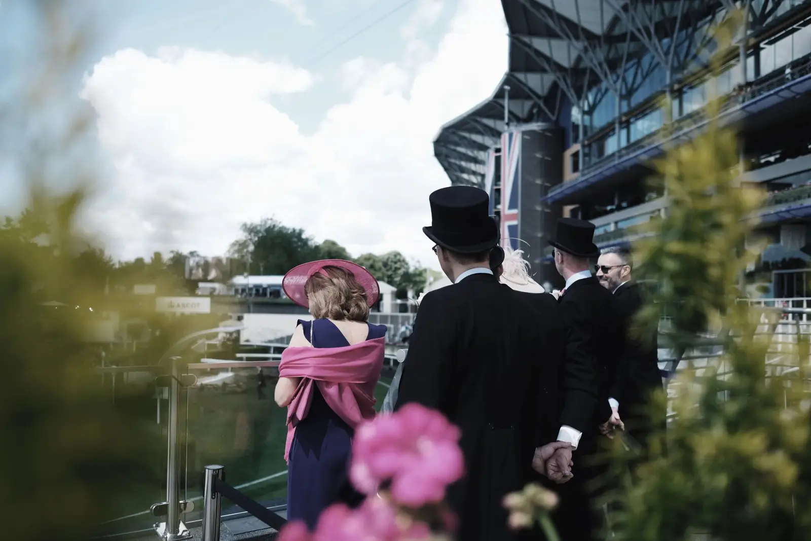 Racegoers in hats and morning dress at the rail